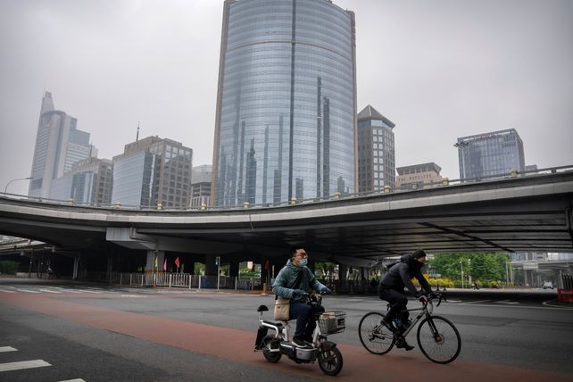 CAPITAL. Dos hombres circulan por una avenida de Beijing en lo que normalmente es la hora pico de la mañana.