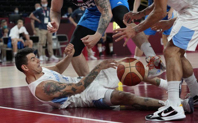 El delantero argentino Gabriel Deck cae al suelo en un intento por tomar el control del balón durante el juego de la ronda preliminar de baloncesto masculino en los Juegos Olímpicos de Verano 2020.