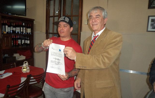 Pionero. El dueño del comedor Balcarce y el titular de la cátedra muestran la adhesión del local al “derecho de jarra”.