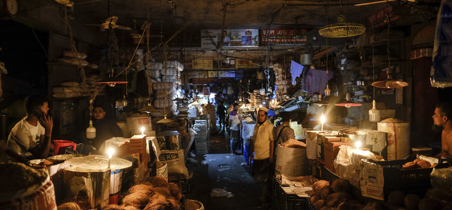 Vendedores encienden velas en un mercado después de que una falla en la red eléctrica nacional de Bangladesh sumiera a gran parte del país en un apagón en Dhaka, Bangladesh, el martes 4 de octubre de 2022.
