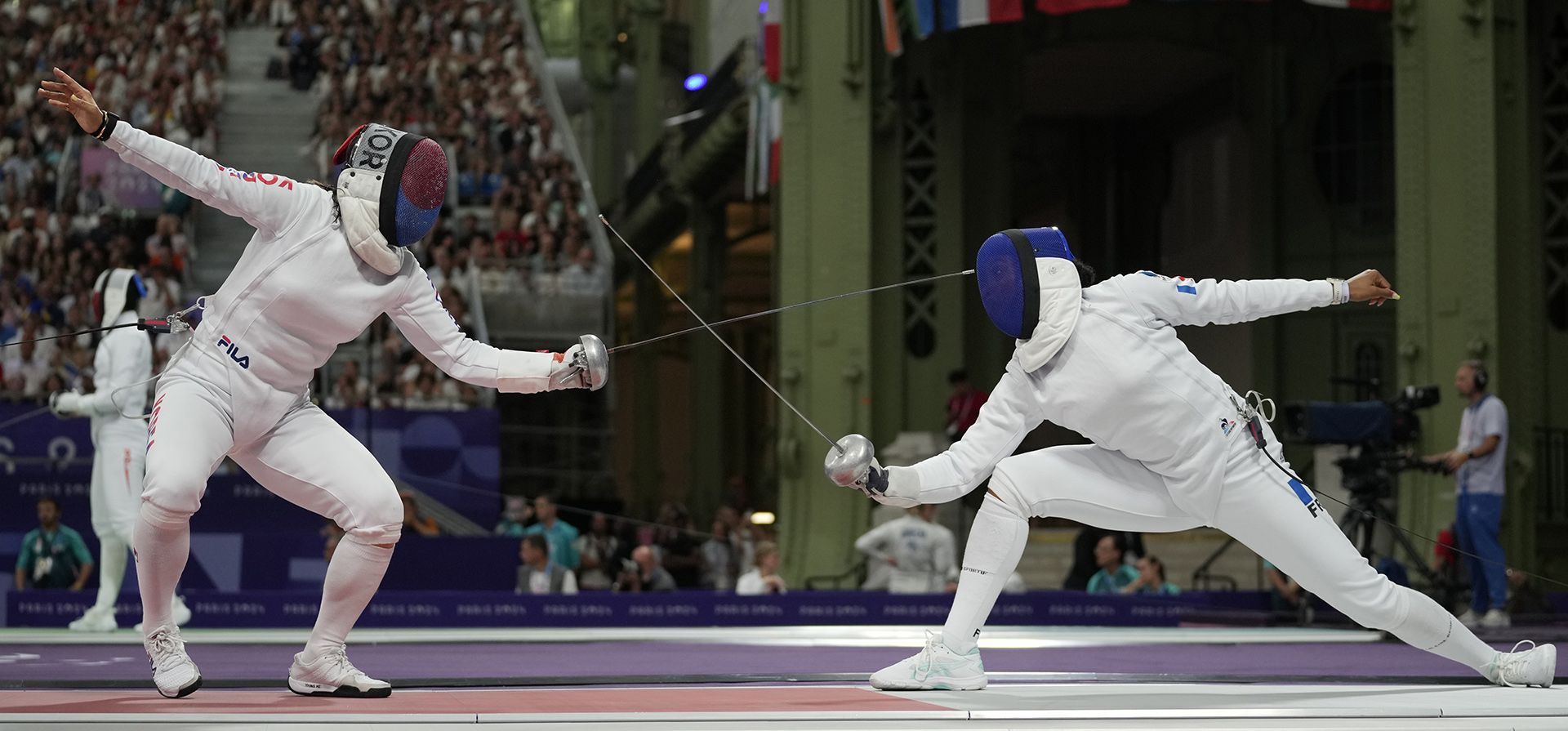 La surcoreana Kang Young Mi, a la izquierda, compite con la francesa Coraline Vitalis en el partido de cuartos de final de espada por equipos femenino durante los Juegos Olímpicos de Verano de 2024 en el Grand Palais, el martes 30 de julio de 2024, en París, Francia. (Foto AP/Andrew Medichini) La surcoreana Kang Young Mi, a la izquierda, compite con la francesa Coraline Vitalis en el partido de cuartos de final de espada por equipos femenino durante los Juegos Olímpicos de Verano de 2024 en el Grand Palais, el martes 30 de julio de 2024, en París, Francia. (Foto AP/Andrew Medichini)