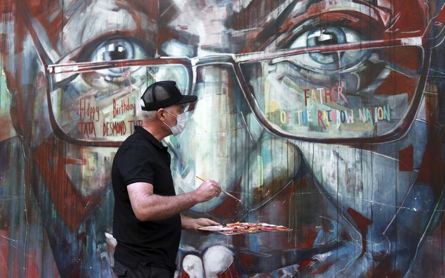 Un mural, que representa al arzobispo emérito anglicano, Desmond Tutu, es restaurado por el artista Brian Rolfe después de que fue vandalizado, Ciudad del Cabo, Sudáfrica. El icono anti-apartheid de Sudáfrica, Tutu cumple 90 años.