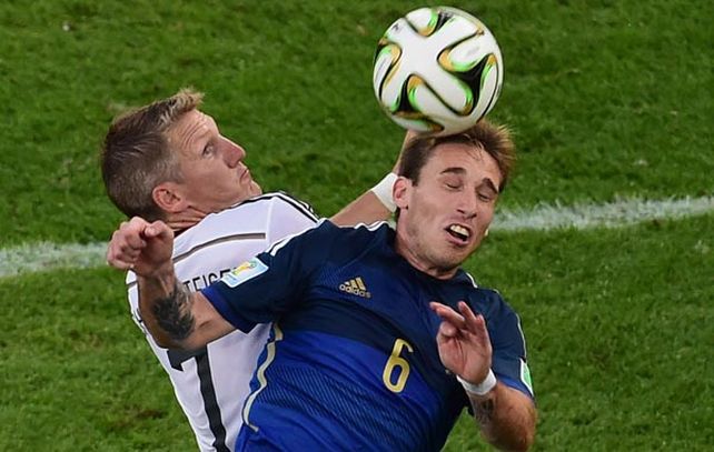 Lucas Biglia pelea la pelota en la altura con Bastian Schweinsteiger en la final del mundial 2014.