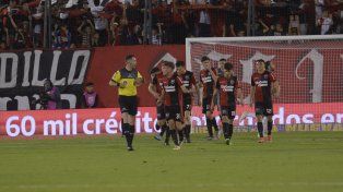 Todo Newells le protesta al árbitro Pablo Dóvalo.