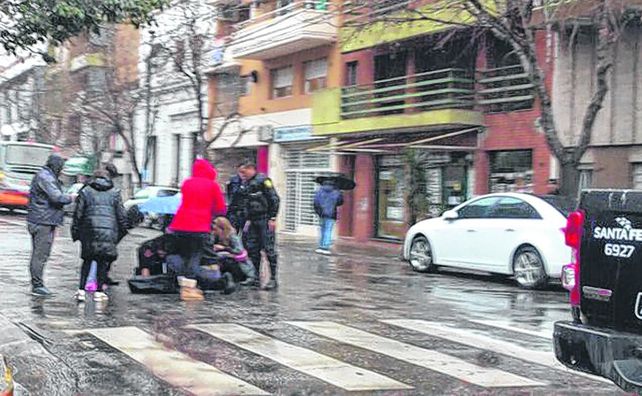 siniestro. La mujer que fue embestida por el ómnibus es auxiliada en la vía pública en Rioja y Ovidio Lagos.