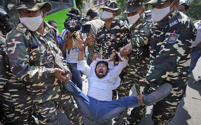 Paramilitares detienen a un activista del ala juvenil del partido del Congreso que protestaba contra el asesinato de cuatro agricultores en el estado de Uttar Pradesh, después de ser atropellado por un automóvil propiedad del ministro del Interior de India en Nueva Delhi, India.