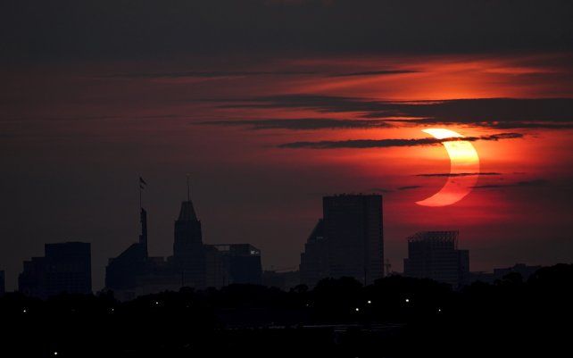 Un eclipse solar parcial se eleva sobre el horizonte de Baltimore, visto desde Arbutus, Maryland.