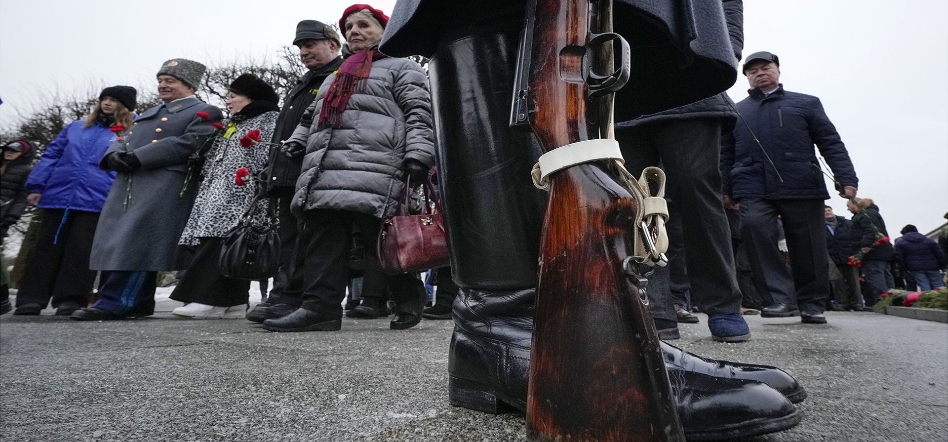 Oficiales y civiles del ejército ruso caminan hacia el monumento a la Patria para colocar flores en el cementerio de Piskaryovskoye, donde fueron enterradas la mayoría de las víctimas del asedio de Leningrado durante la Segunda Guerra Mundial, en San Petersburgo, Rusia, el viernes 27 de enero de 2023. (Foto AP/Dmitri Lovetsky)