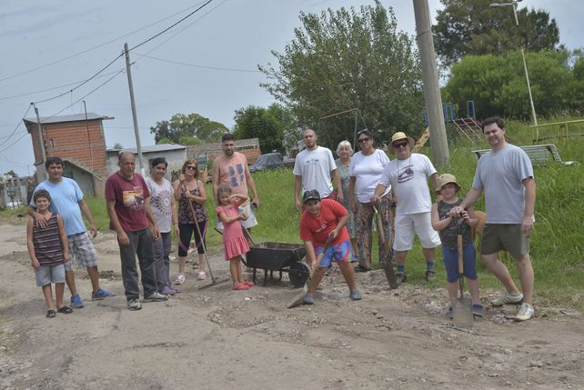 Sin asfalto y cansados del abandono, vecinos con palas arreglan su calle