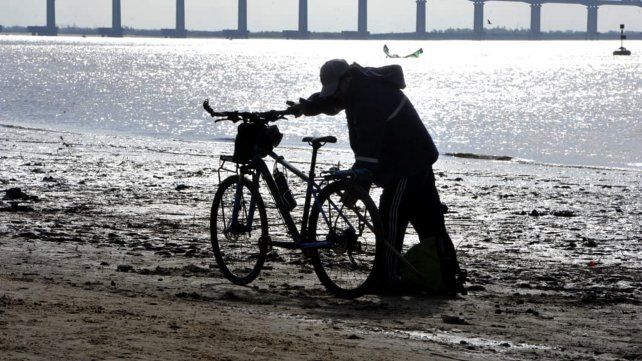 Un hombre busca metales y otros objetos en el barro.  