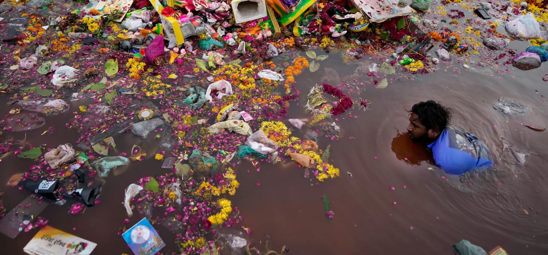Ahmedabad, India. Un hombre busca material reutilizable entre ídolos de la diosa hindú Dashama sumergidos por devotos en el río Sabarmati. Fotografía: Ajit Solanki/AP Ahmedabad, India. Un hombre busca material reutilizable entre ídolos de la diosa hindú Dashama sumergidos por devotos en el río Sabarmati. Fotografía: Ajit Solanki/AP