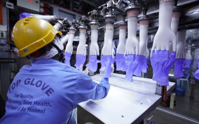 Un trabajador inspecciona guantes desechables en la fábrica Top Glove en Shah Alam, en las afueras de Kuala Lumpur, Malasia. El mayor fabricante de guantes de goma del mundo espera una demora en las entregas luego de que fue golpeada por un brote de coronavirus que afectó a miles de trabajadores.