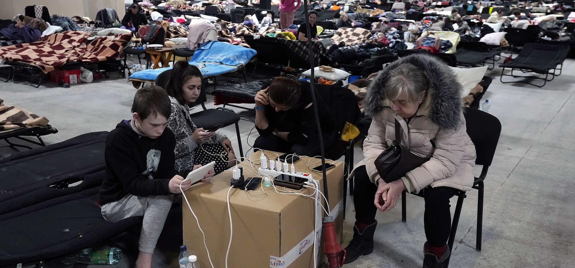 Refugiados ucranianos cargan sus dispositivos electrónicos en un lugar para refugiados en Nadarzyn, cerca de Varsovia, Polonia, el jueves 17 de marzo de 2022. Polonia ha admitido a unos 1,95 millones de refugiados que huyen de la guerra y la agresión rusa contra Ucrania.