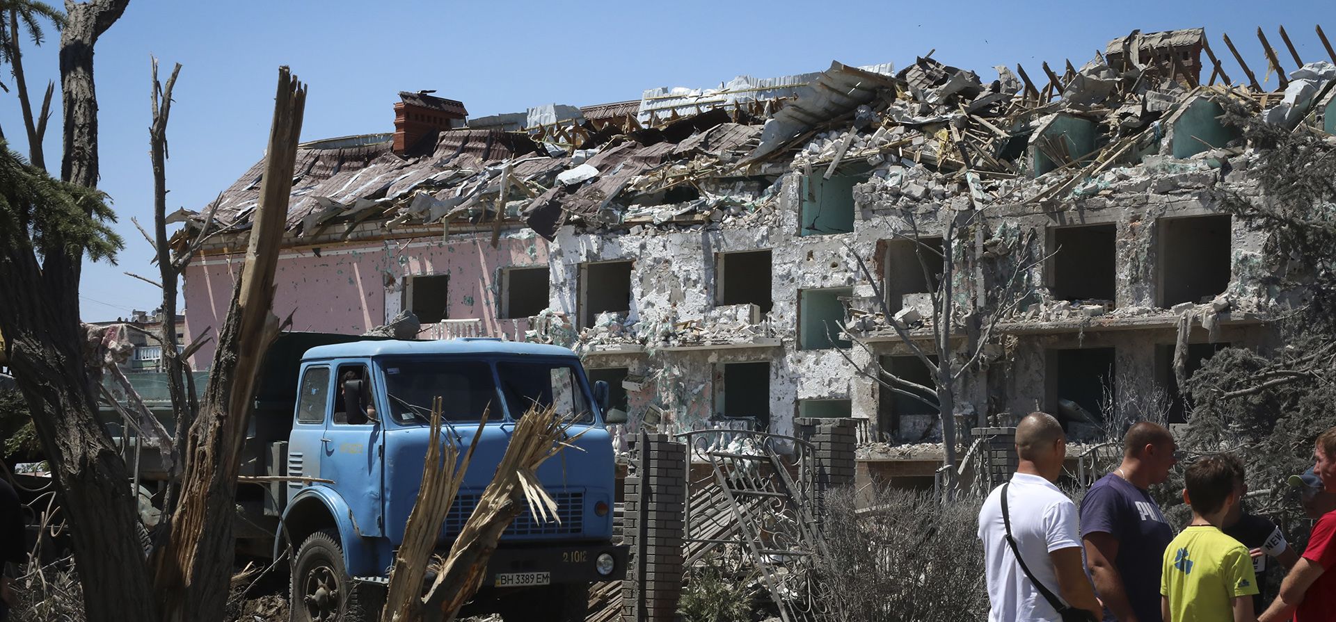 Los residentes locales observan un edificio dañado en la ciudad de Serhiivka, ubicada a unos 50 kilómetros al suroeste de Odesa, Ucrania, el viernes 1 de julio de 2022. Ataques con misiles rusos en áreas residenciales en una ciudad costera cerca de la ciudad portuaria de Ucrania de Odesa la madrugada del viernes mató al menos a 19 personas, informaron las autoridades, un día después de que las fuerzas rusas se retiraran de una isla estratégica del Mar Negro.