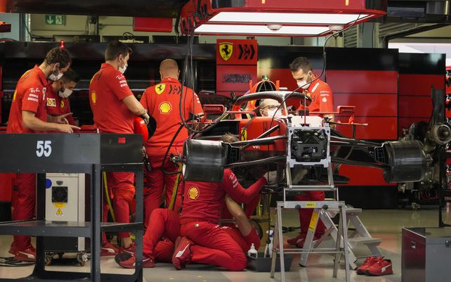 Los técnicos trabajan en el coche del piloto de Ferrari Carlos Sainz en el garaje del equipo en el circuito de Sochi Autodrom, en Sochi, Rusia, el jueves 23 de septiembre de 2021. El Gran Premio de Fórmula Uno de Rusia se celebrará el domingo.