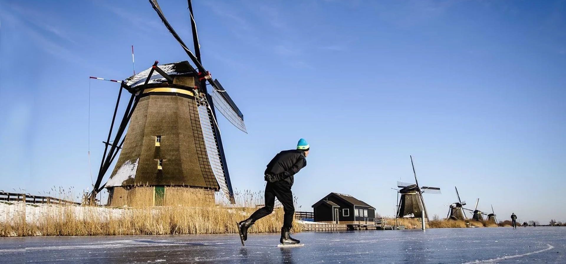 Un hombre patina sobre hielo junto a unos molinos de viento, este 13 de febrero de 2021 en Kinderdijk, Holanda. Foto: EFE/EPA