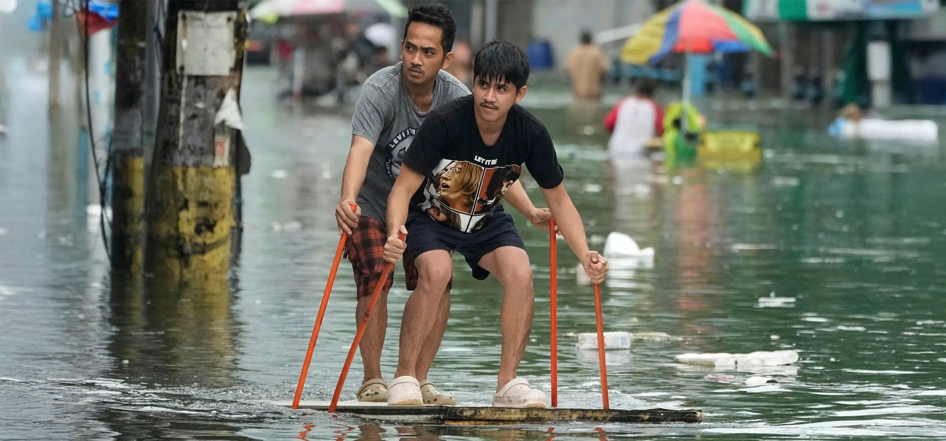 La gente usa postes para montar una carroza improvisada a lo largo de una carretera inundada. El tifón Co-may ha intensificado las lluvias monzónicas estacionales, Malabon, Filipinas. Fotografía: Aaron Favila/AP La gente usa postes para montar una carroza improvisada a lo largo de una carretera inundada. El tifón Co-may ha intensificado las lluvias monzónicas estacionales, Malabon, Filipinas. Fotografía: Aaron Favila/AP