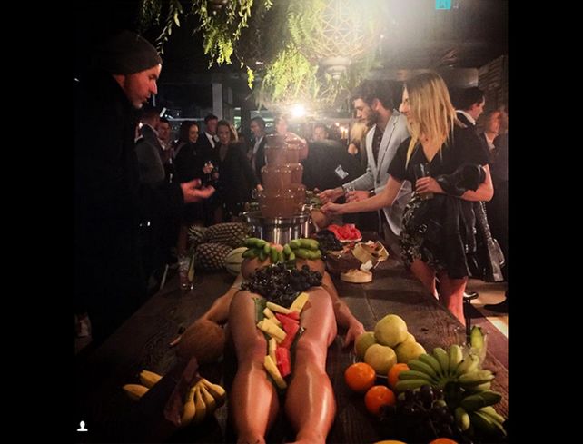 Polémica por un bar que utiliza a mujeres desnudas como bandejas sobre la mesa para servir frutas
