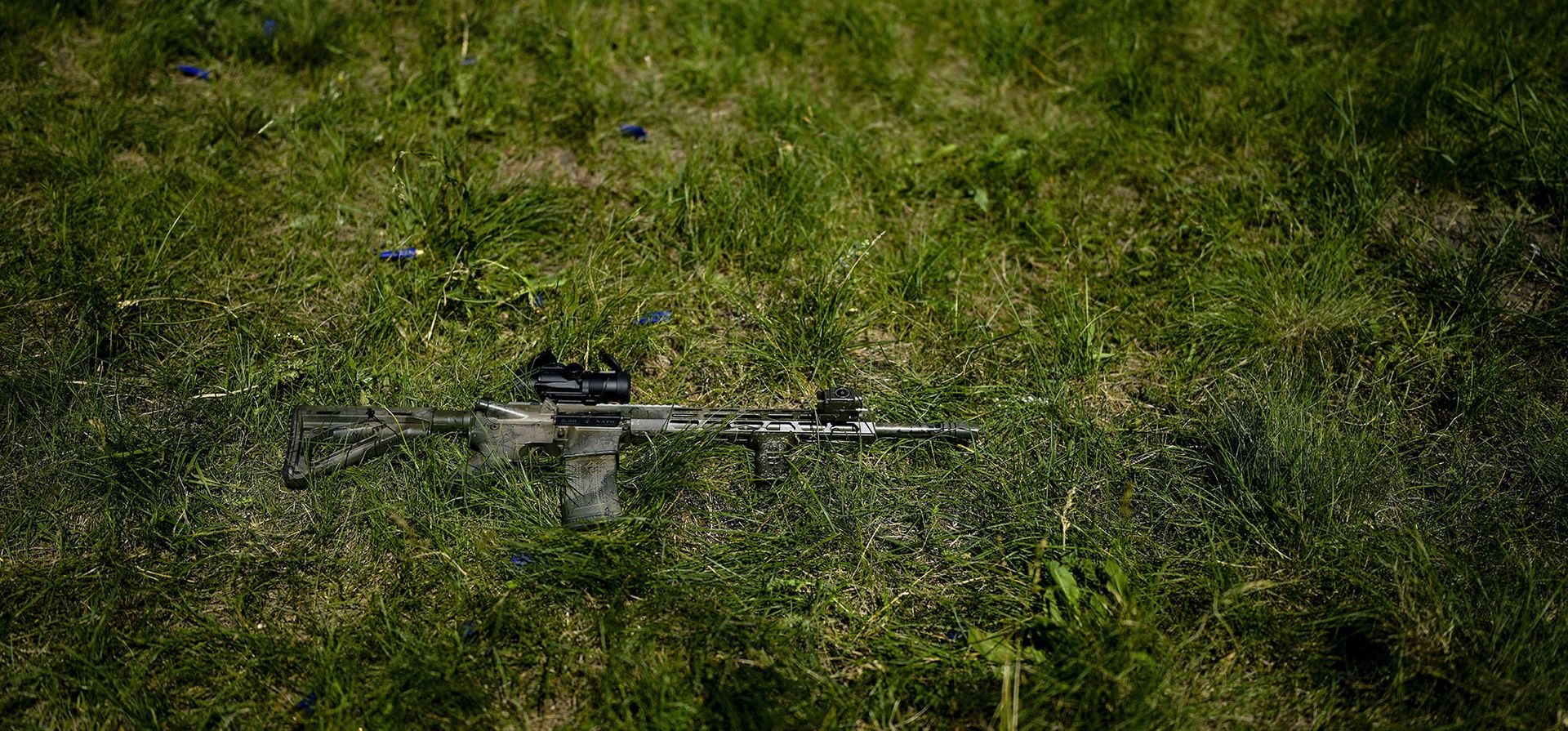 Se ve un rifle apoyado en el césped mientras milicianos civiles entrenan en un campo de tiro en las afueras de Kyiv.