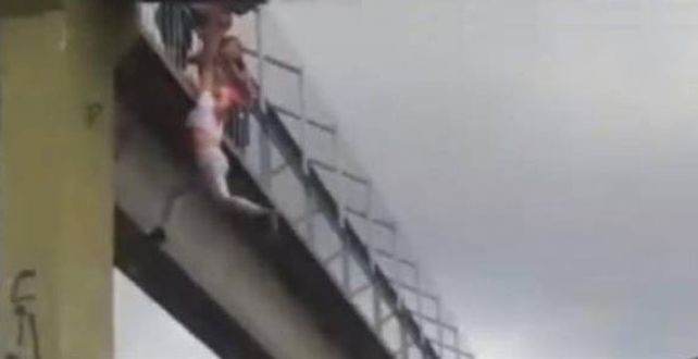 Los vecinos colaboraron y auxiliaron al policía para poder subir a la mujer a un lugar seguro.