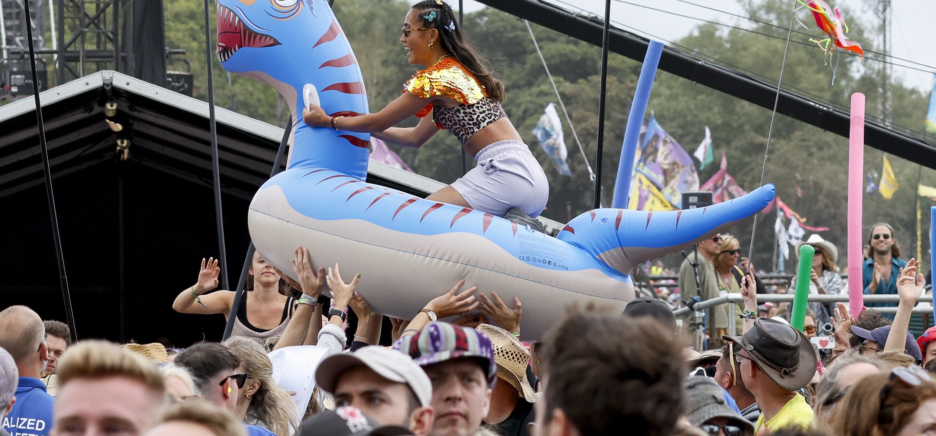 Una joven monta un inflable entre la audiencia en la actuación de Shania Twain durante el Festival de Glastonbury en Worthy Farm, Somerset, Inglaterra, el domingo 30 de junio de 2024. (Joel C Ryan/Invision/AP)