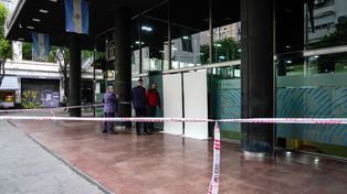 Personal del Banco Nación revisa la estructura provisoria donde estaba el vidrio chocado.