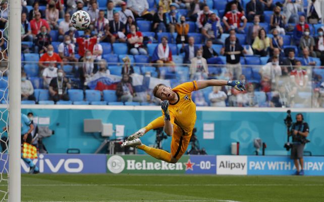 El arquero finlandés Lukas Hradecky observa el balón mientras el ruso Aleksei Miranchuk marca el primer gol de su equipo durante el partido del grupo B del campeonato de fútbol de la Euro 2020 entre Rusia y Finlandia en el estadio de San Petersburgo