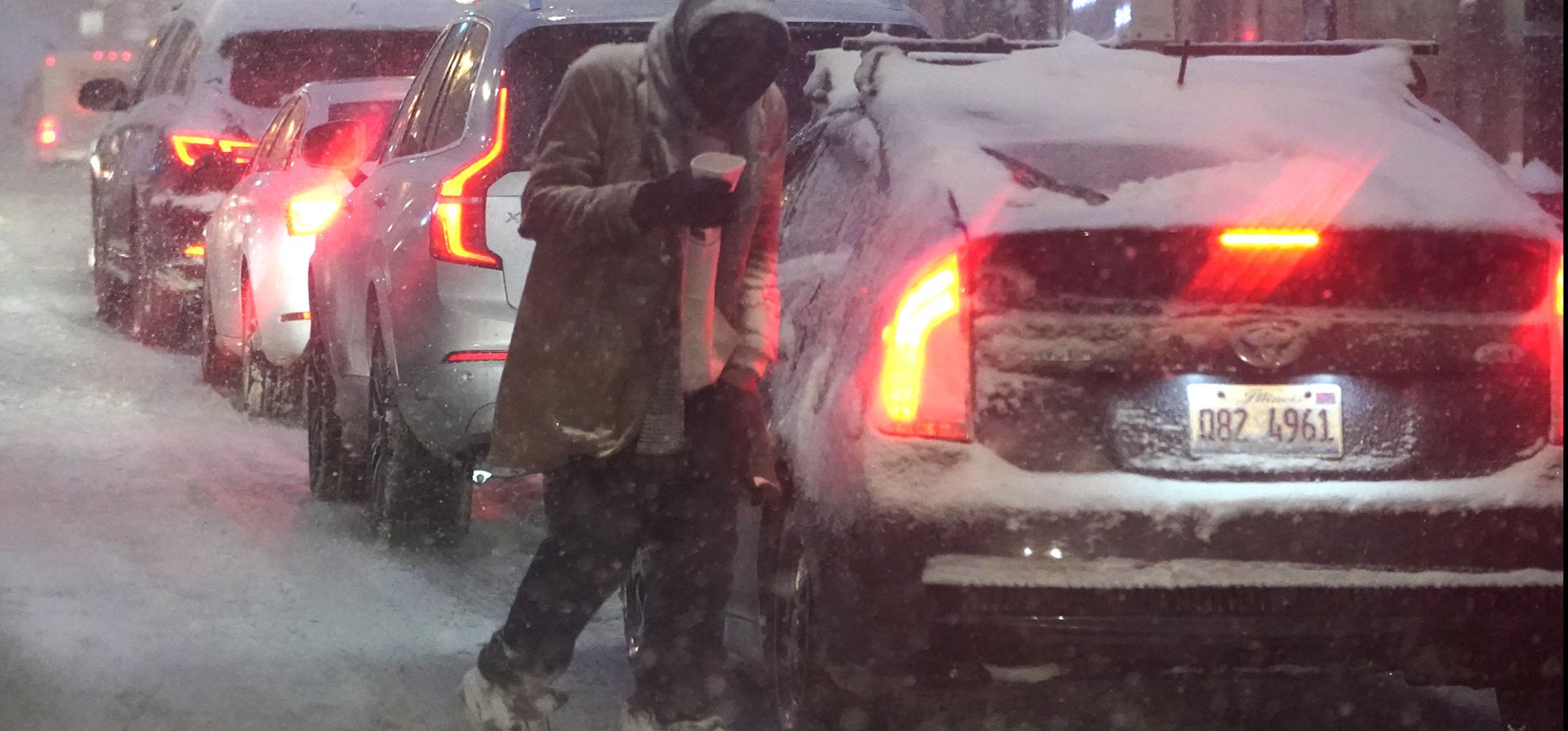 Un homeless camina entre los autos mientras la nieve que cae convierte la calles fangosas en Chicago. Una gran tormenta invernal a su paso trajo una mezcla de lluvia helada y nieve en la parte central de los Estados Unidos cuando las aerolíneas cancelaron cientos de vuelos, los gobernadores instaron a los residentes a mantenerse alejados de las carreteras y las escuelas cerraron sus campus.