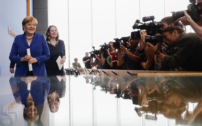 Fotógrafos y cámaras de televisión cubren a la canciller alemana Angela Merkel cuando sale de una conferencia de prensa en Berlín, Alemania. Angela Merkel dejará el cargo en los próximos meses con su popularidad intacta, pese a la derrota de su partido en las elecciones.