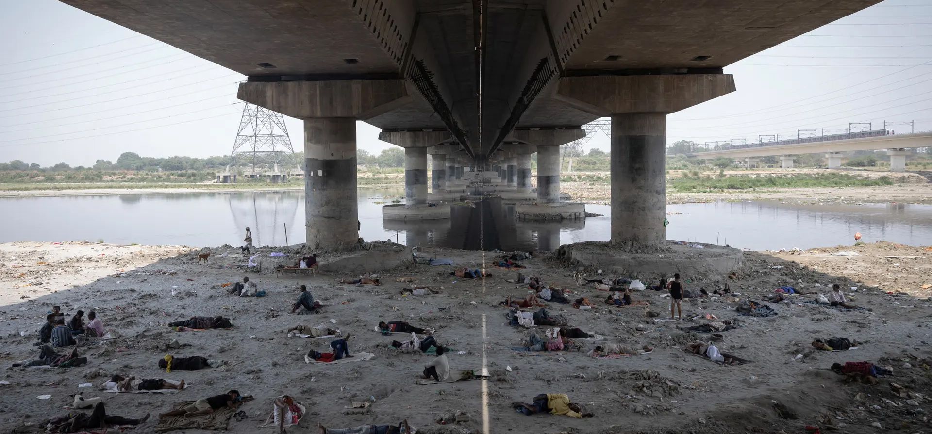 La gente duerme en el lecho del río Yamuna, debajo de un puente, durante una ola de calor, Delhi, India. Fotografía: Adnan Abidi/Reuters La gente duerme en el lecho del río Yamuna, debajo de un puente, durante una ola de calor, Delhi, India. Fotografía: Adnan Abidi/Reuters