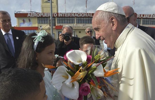 El Papa recibe un ramo de flores a su arribo al aeropuerto de Santiago de Cuba.