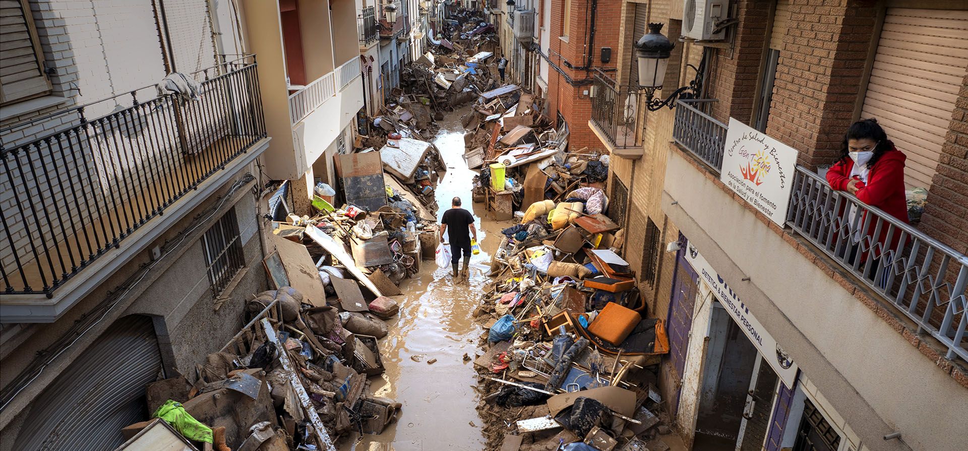 Varias personas caminan por una calle entre muebles y escombros apilados a los lados de un área afectada por las inundaciones, en Paiporta, Valencia, España, el martes 5 de noviembre de 2024. (AP Foto/Emilio Morenat Varias personas caminan por una calle entre muebles y escombros apilados a los lados de un área afectada por las inundaciones, en Paiporta, Valencia, España, el martes 5 de noviembre de 2024. (AP Foto/Emilio Morenat