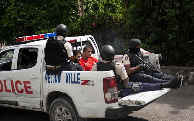 La policía lleva a dos detenidos a la comisaría de policía de Petion Ville en Puerto Príncipe