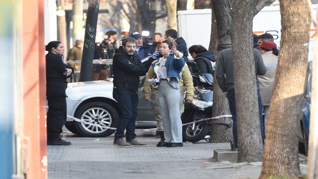 El fiscal Miguel Moreno y la pareja de Ariel Señuque delante del auto donde mataron al hombre.&nbsp;