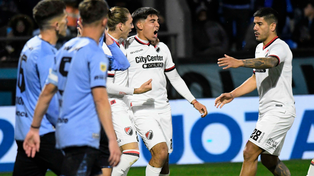 Juan Sforza celebra su gol abrazado con Schor. Se acerca Recalde para festejar.