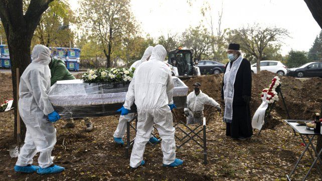 Portadores de un féretro llevan un ataúd mientras un sacerdote ortodoxo observa, durante una ceremonia fúnebre por una persona que murió de COVID-19, en la ciudad norteña de Tesalónica, Grecia.
