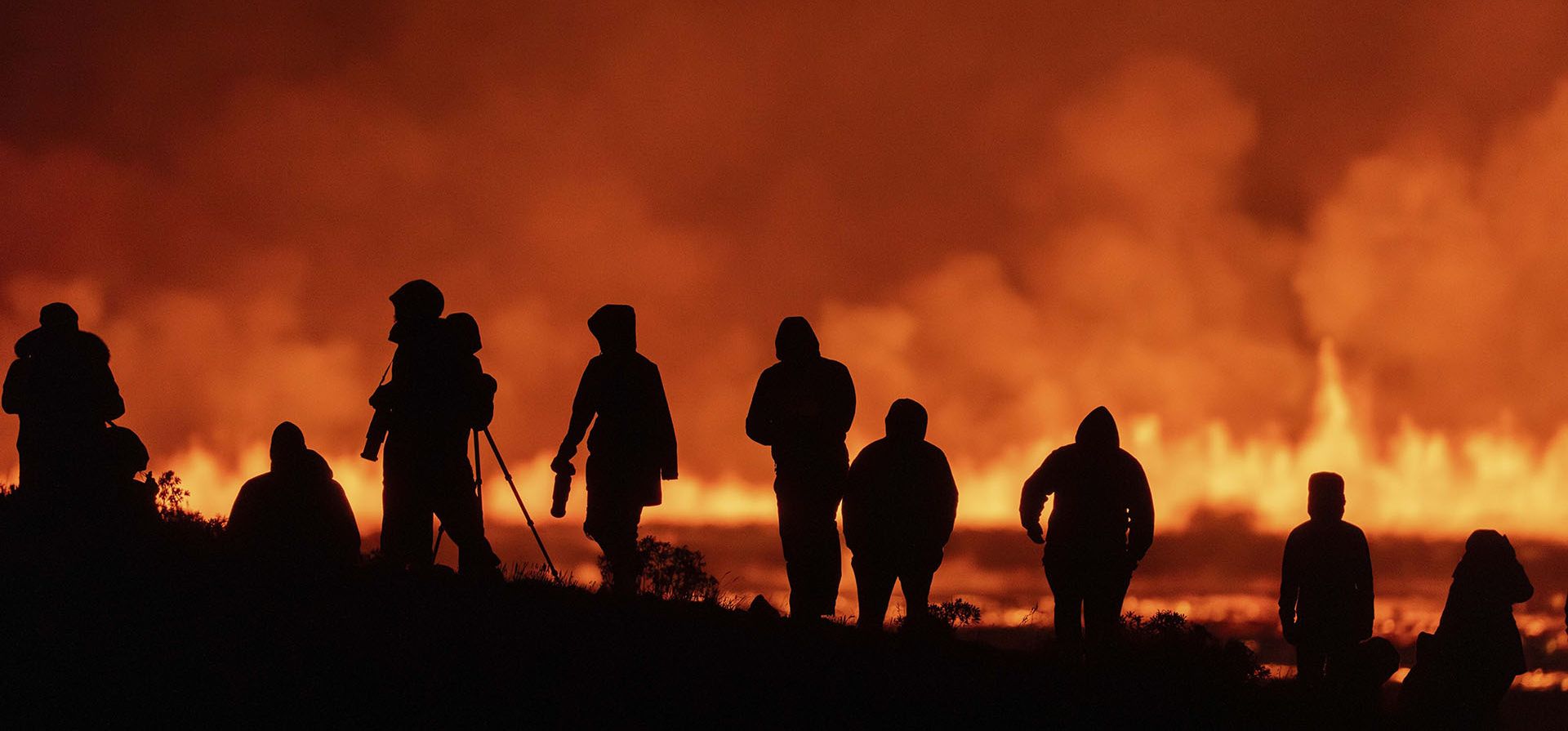 Turistas y visitantes tratan de ver la erupción de un volcán en la distancia, desde la intersección entre Reykjanesbraut y la carrera a Grindavik, Islandia, el 22 de agosto de 2024. (AP Foto/Marco di Marco) Turistas y visitantes tratan de ver la erupción de un volcán en la distancia, desde la intersección entre Reykjanesbraut y la carrera a Grindavik, Islandia, el 22 de agosto de 2024. (AP Foto/Marco di Marco)