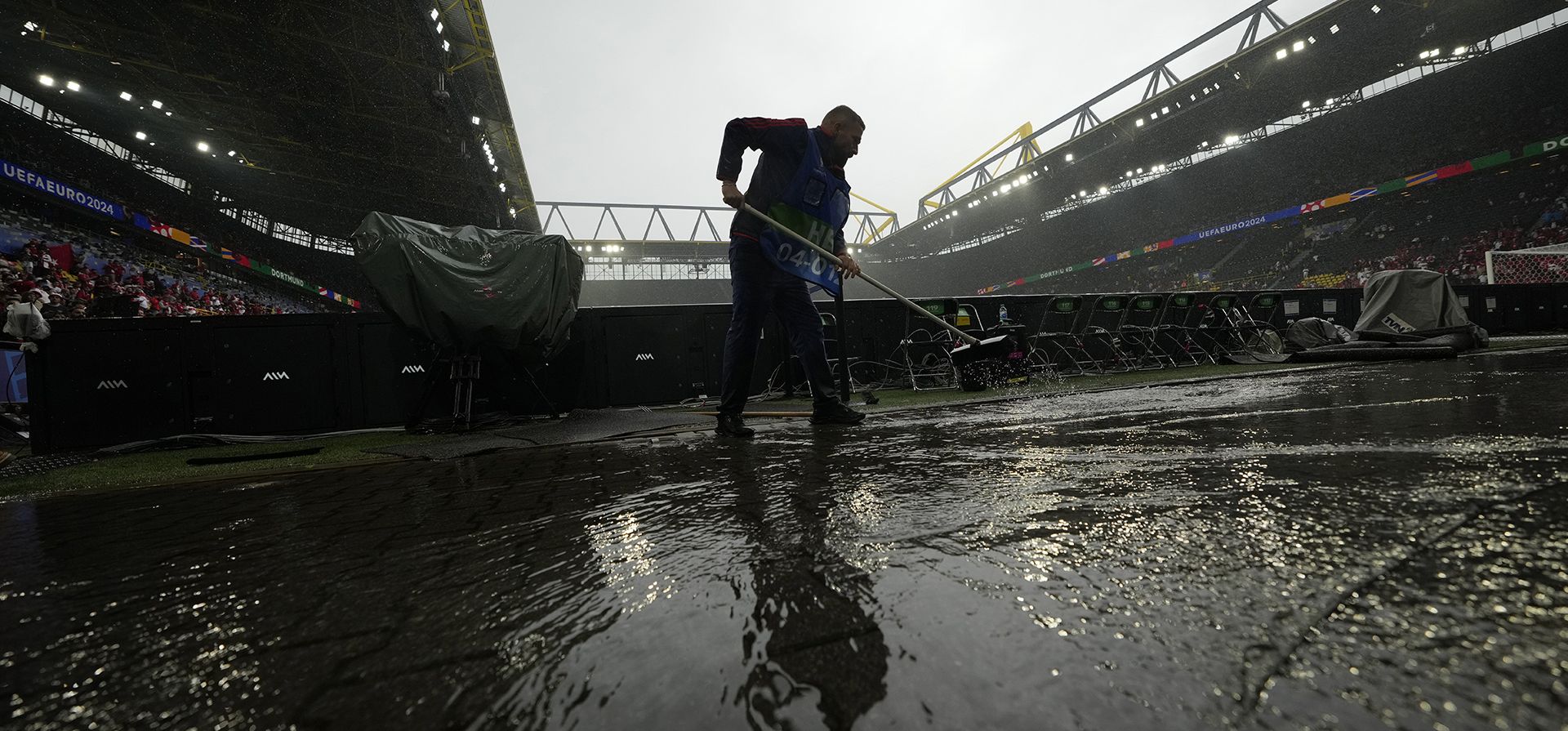 Personal de mantenimiento limpia el agua del suelo antes del inicio de un partido del Grupo F entre Turquía y Georgia en el torneo de fútbol Euro 2024 en Dortmund, Alemania, el martes 18 de junio de 2024. (Foto AP/Alessandra Tarantino) Personal de mantenimiento limpia el agua del suelo antes del inicio de un partido del Grupo F entre Turquía y Georgia en el torneo de fútbol Euro 2024 en Dortmund, Alemania, el martes 18 de junio de 2024. (Foto AP/Alessandra Tarantino)