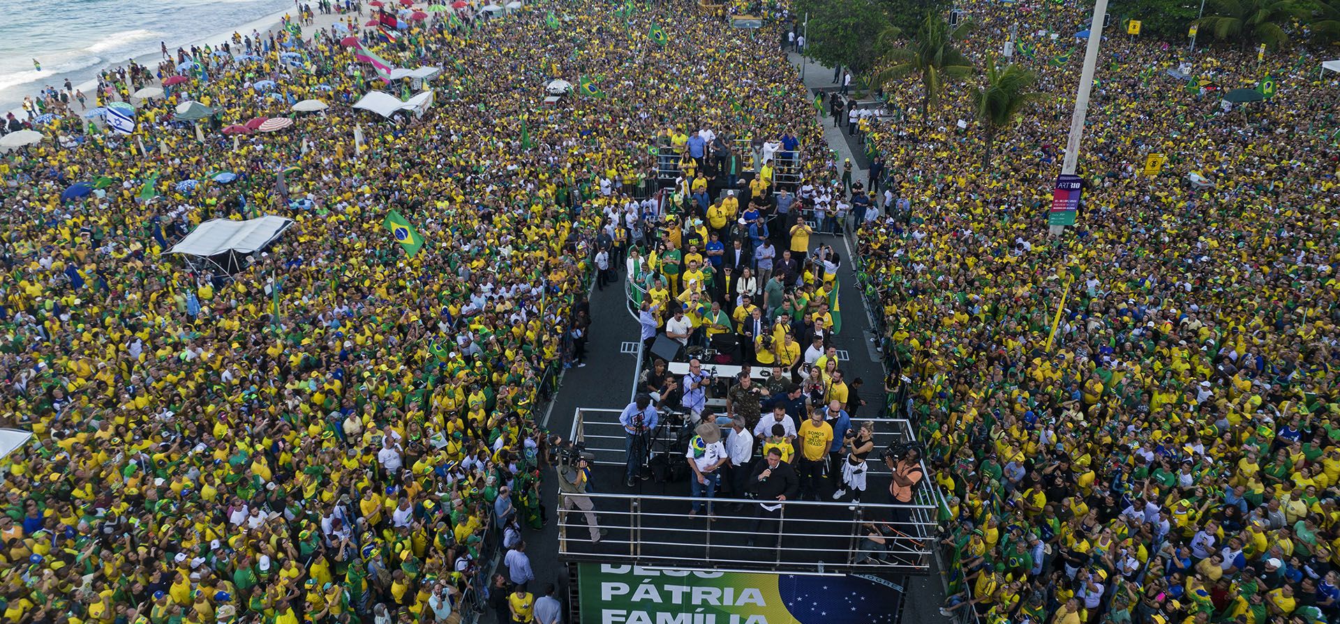 El presidente de Brasil, Jair Bolsonaro, se para en un escenario adornado con una pancarta con un mensaje que dice en portugués; "Dios, patria y familia", mientras saluda a sus simpatizantes reunidos en la playa de Copacabana durante la celebración del Día de la Independencia, en Río de Janeiro, Brasil. Bolsonaro está librando una campaña total para apuntalar la crucial voto evangélico antes de las elecciones del 2 de octubre.