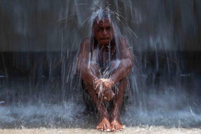 Un hombre se refresca en una fuente del parque Madureira