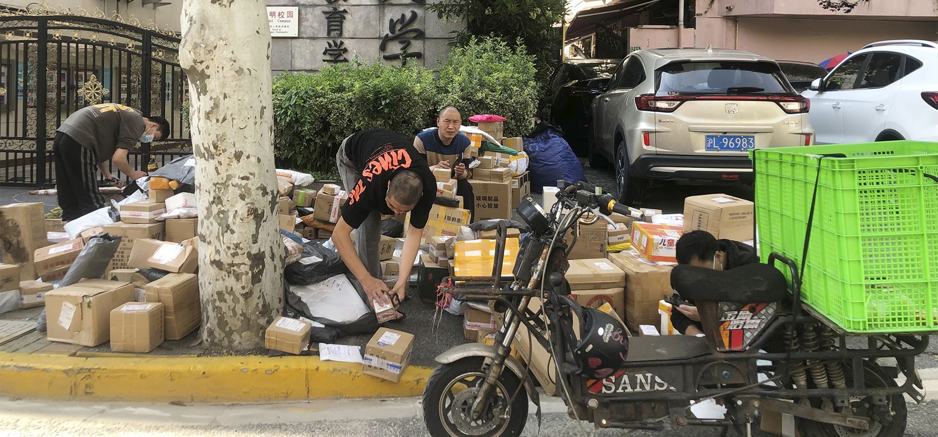 Repartidores clasifican paquetes en la calle en Shanghai, China. Numerosos complejos residenciales en Beijing han restringido el movimiento de entrada y salida, aunque las condiciones siguen siendo mucho menos severas que en Shanghai, donde millones de ciudadanos han estado bajo diferentes condiciones y grados de encierro durante dos meses.