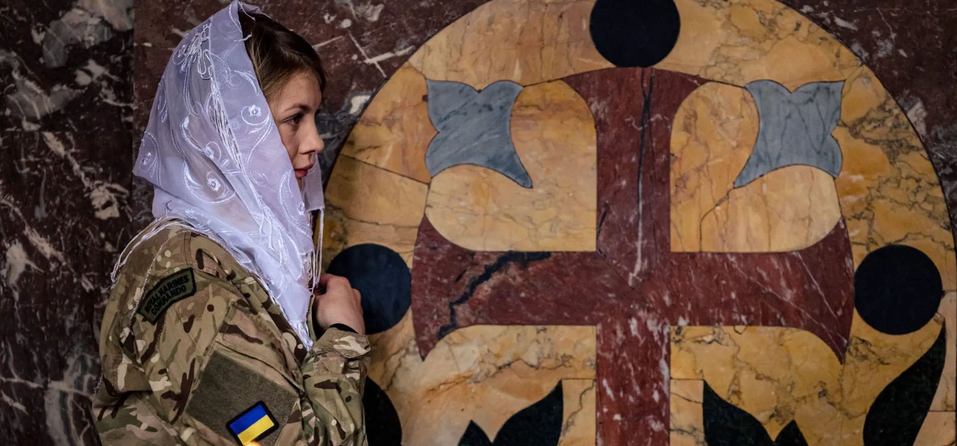 Una soldado ucraniana se cruza durante un servicio ortodoxo de Pascua en la Catedral de San Volodymyr en Kiev, Ucrania. Fotografía: Dimitar Dilkoff/AFP/Getty Images