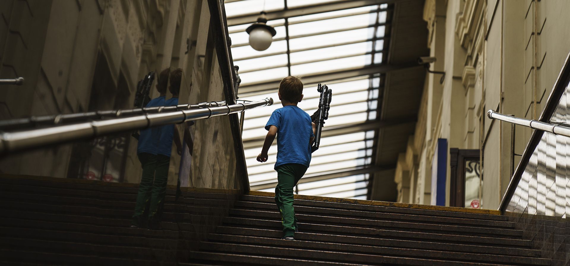 Un niño juega con un arma de juguete mientras espera el tren en la estación de Lviv, Ucrania, el miércoles 27 de julio de 2022.