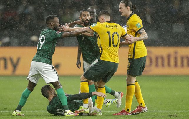 Fhad Mosaed Almuwallad de Arabia Saudita empuja al australiano Ajdin Hrustic mientras patea a un compañero de equipo durante el partido de la tercera ronda del grupo B de la clasificación asiática para la Copa Mundial 2022 entre Australia y Arabia Saudita en Sydney, Australia, el jueves 11 de noviembre de 2021.
