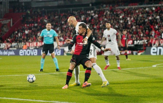 El Colo Ramírez intenta ante Carlos Quintana. Newells enfrenta a Riestra en el Coloso.