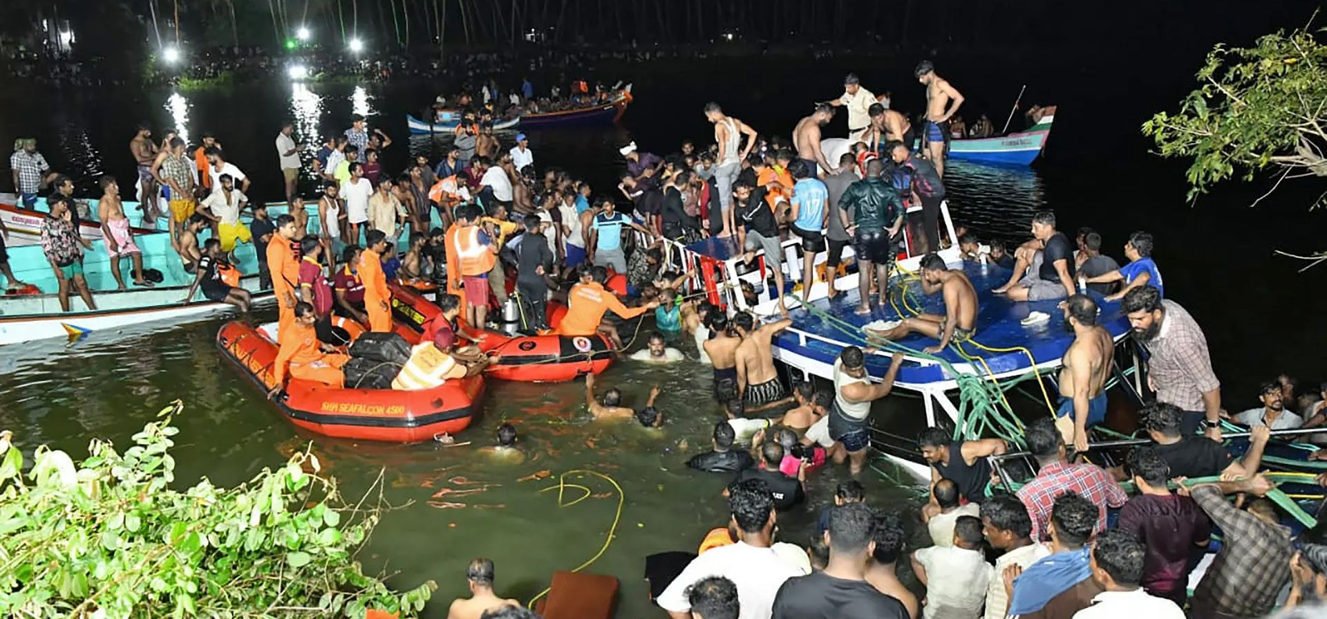 Malappuram, India. La gente lleva a cabo una operación de rescate en el lugar de un accidente de barco en Tanur. Al menos 20 personas murieron cuando un barco turístico de dos pisos volcó en Kerala. Fotografía: AFP/Getty Images