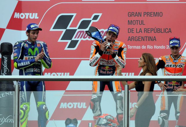Me lo como todo. Márquez recibe el trofeo y parece querer darle un mordiscón mientras el gran Valentino Rossi aplaude tibiamente.