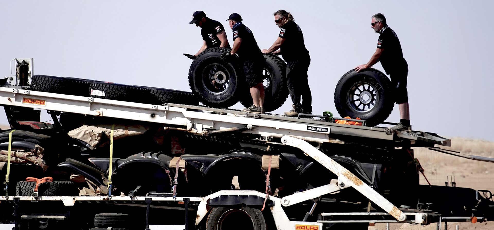Mecánicos cargan ruedas dos días antes del inicio del Rally Dakar en Bisha, Arabia Saudita, el miércoles 1 de enero de 2025. (Foto AP/Christophe Ena)