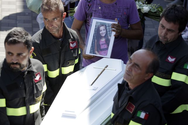 Conmovidos. Rescatistas trasladan el féretro de Giulia. Tenía 9 años.
