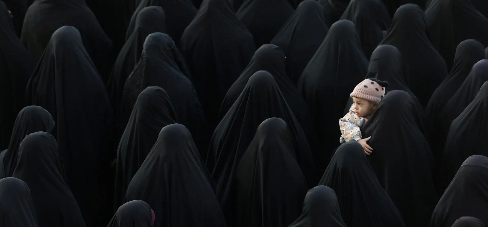 Una mujer sostiene a un niño mientras la gente se reúne para el funeral de Sadegh Omidzadeh y Mohammad-Amin Samadi, miembros del Cuerpo de los Guardianes de la Revolución Islámica, Teherán, Irán. Fotografía: Agencia de Noticias Wana/Reuters Una mujer sostiene a un niño mientras la gente se reúne para el funeral de Sadegh Omidzadeh y Mohammad-Amin Samadi, miembros del Cuerpo de los Guardianes de la Revolución Islámica, Teherán, Irán. Fotografía: Agencia de Noticias Wana/Reuters